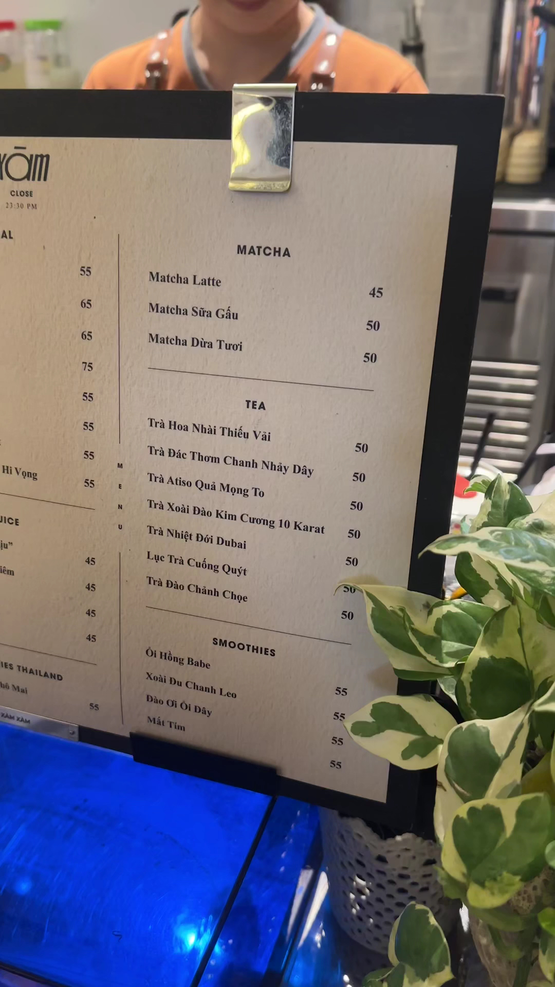 Bảng menu viết phấn treo trên tường gạch của quán.